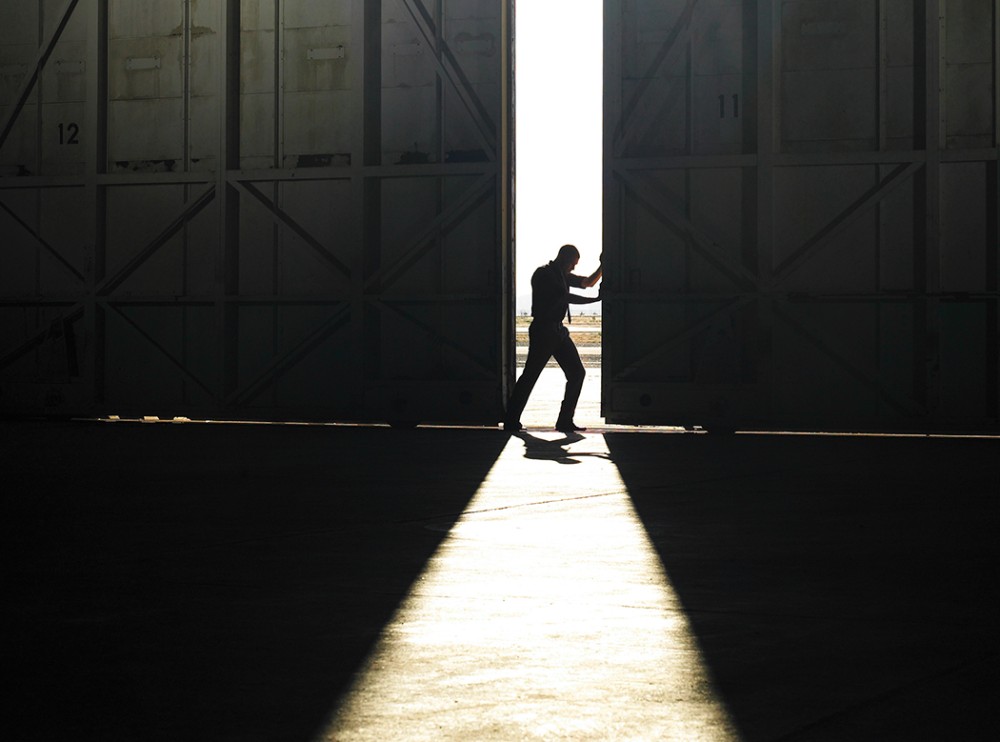 man pushing door