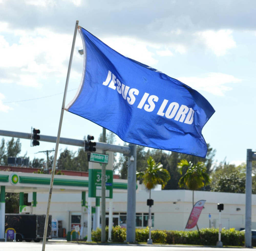 a blue flag with the words "Jesus is Lord"