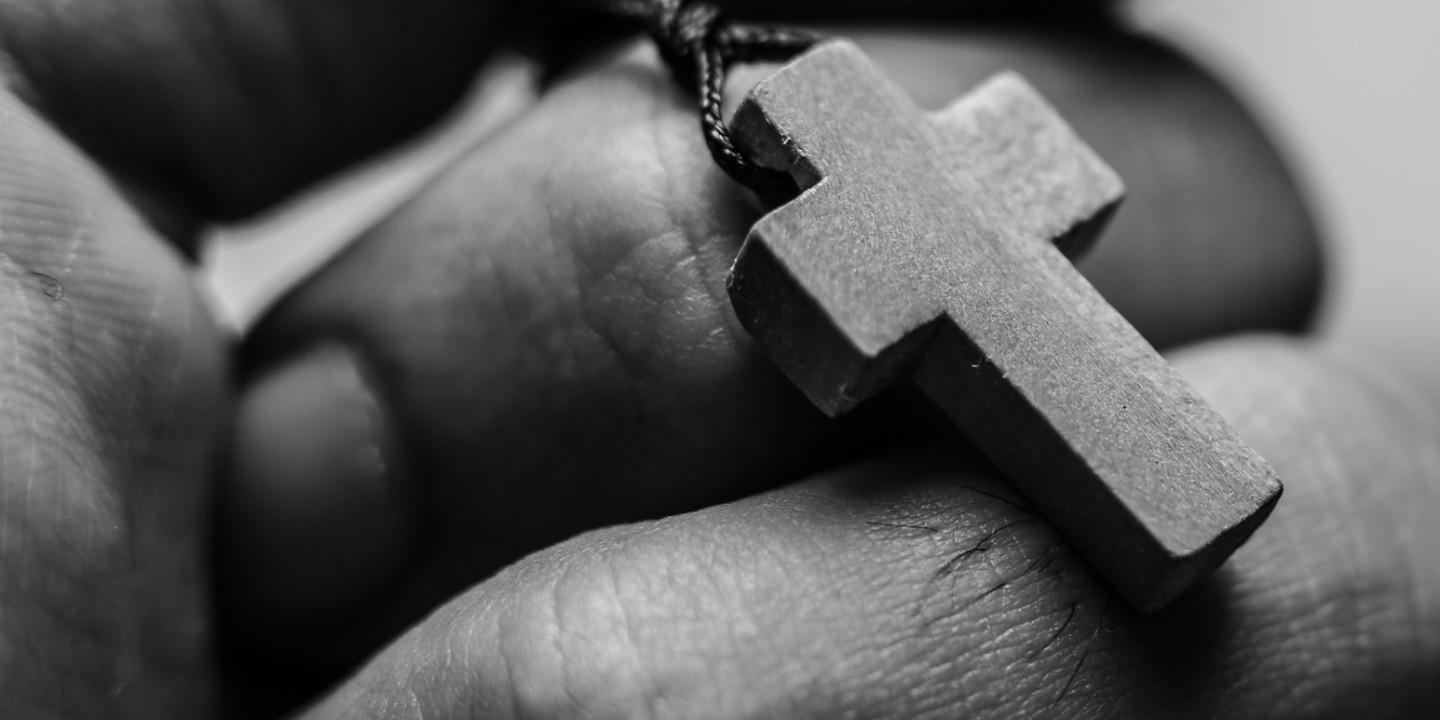 hand holding cross necklace