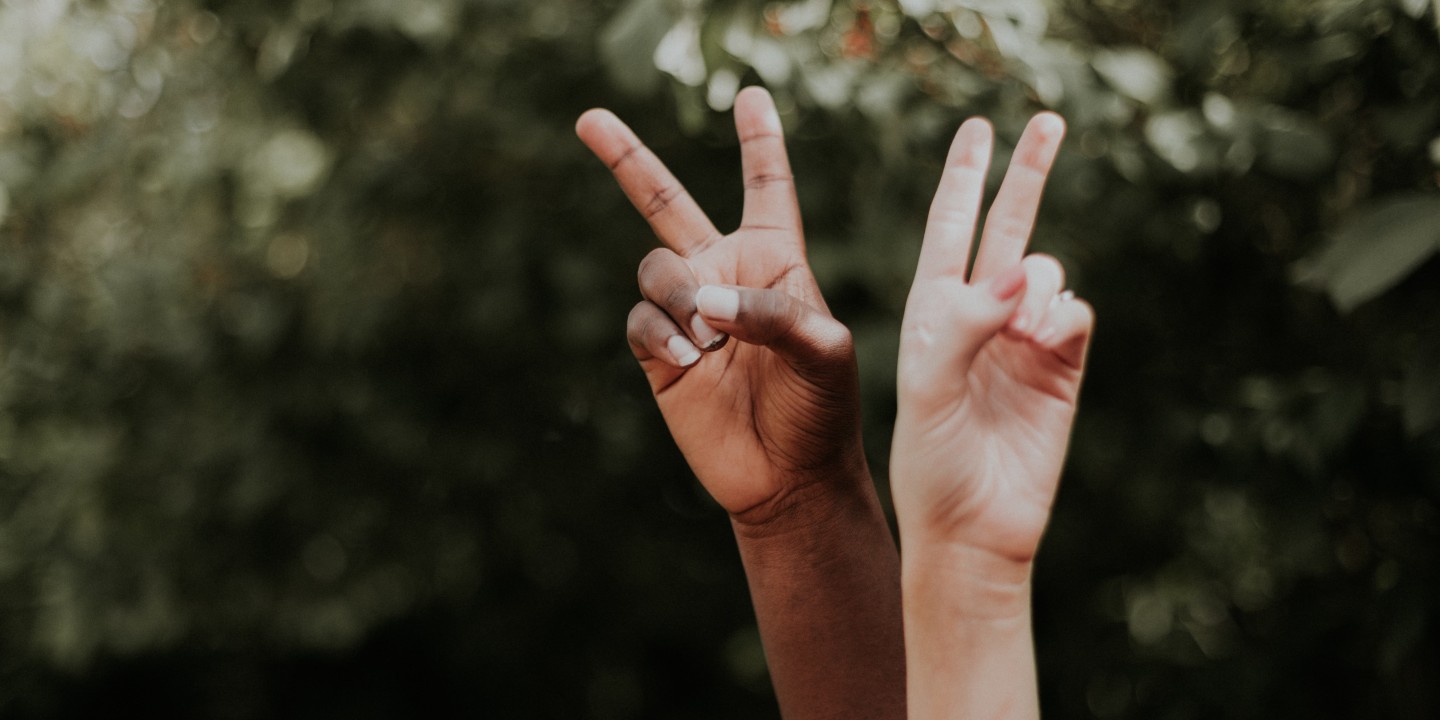 Two hands displaying peace signs